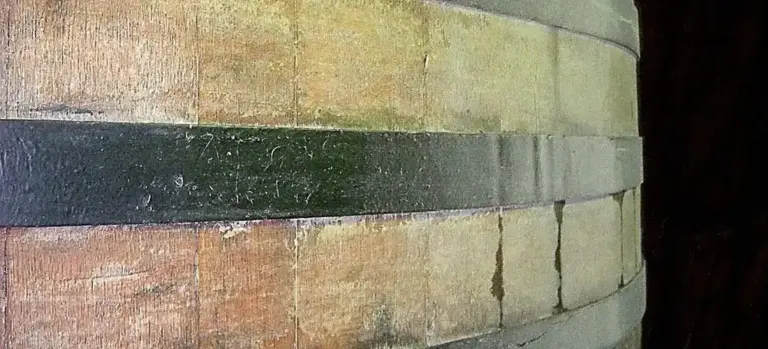 Close-up of a wooden barrel showing curved staves bound by metal hoops