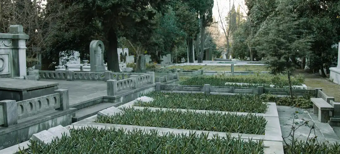 Cemetery with neatly arranged burial plots, hedges, and stone monuments, illustrating different plot sizes and configurations.