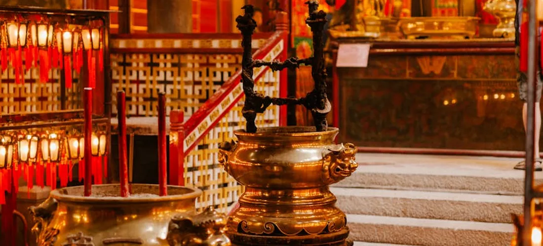 Ceremonial altar with ornate cremation urns and lit candles.