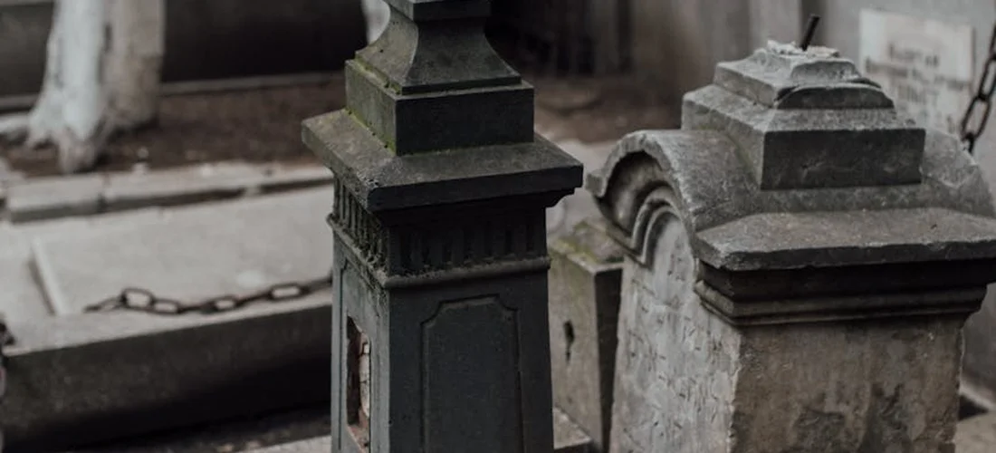Gravestones in a cemetery with a chain, illustrating end-of-life planning and funeral expenses.