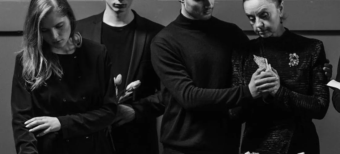 Group of mourners dressed in black in a somber setting, representing funeral planning and decision-making