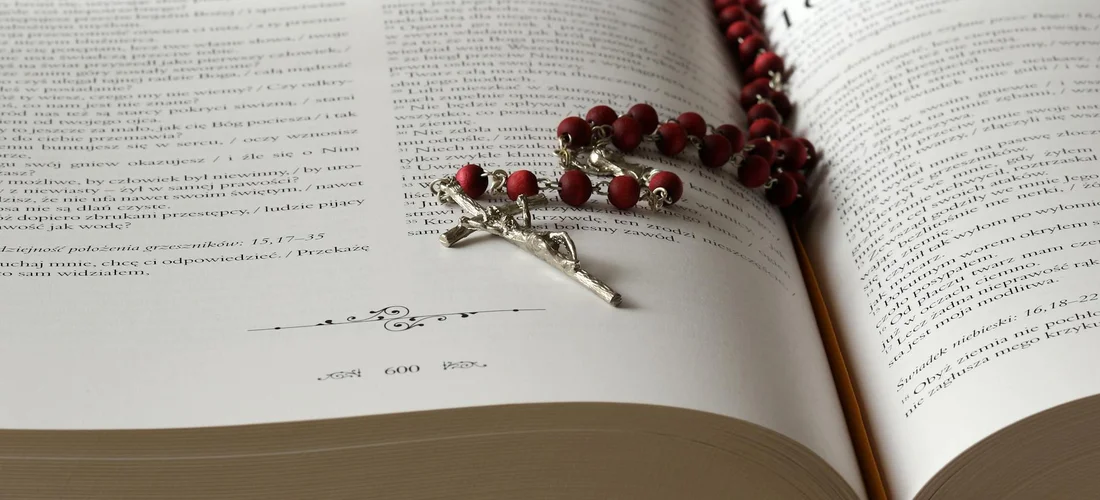 An open book with a rosary resting on its pages, symbolizing heartfelt messages left for loved ones