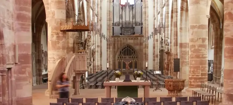 Interior view of a chapel with rows of seats, an altar, and organ at the back, a solemn space used for visitations and funeral services.