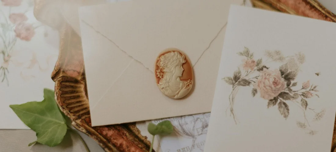 Envelope with a wax seal placed among floral stationery, suggesting a discreet monetary gift for a funeral.