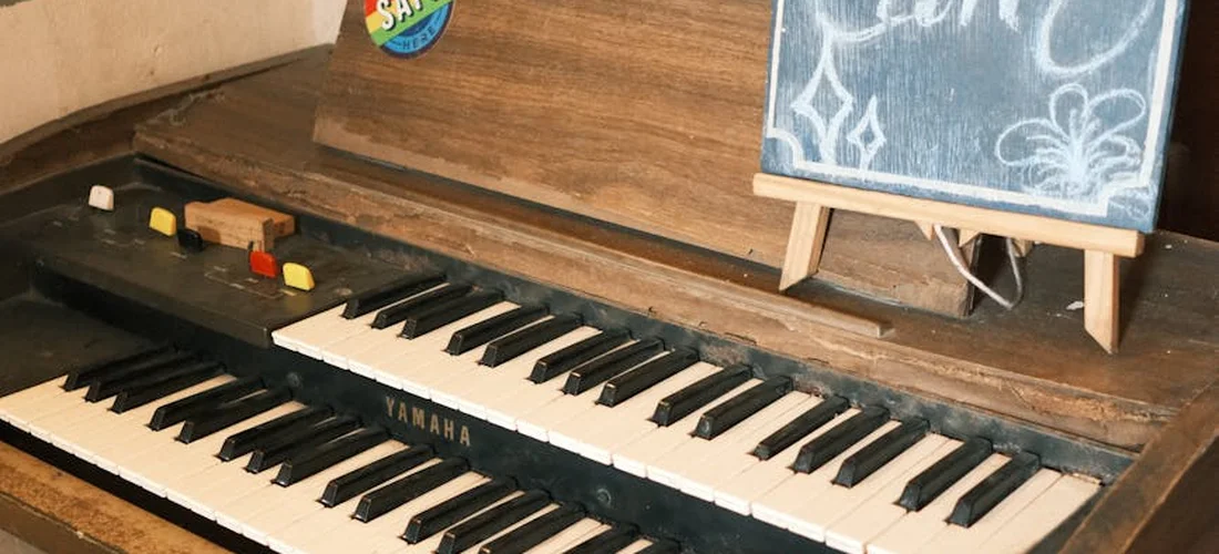 A Yamaha keyboard built into a wooden setup with a chalkboard sign nearby, suggesting nontraditional funeral music options.
