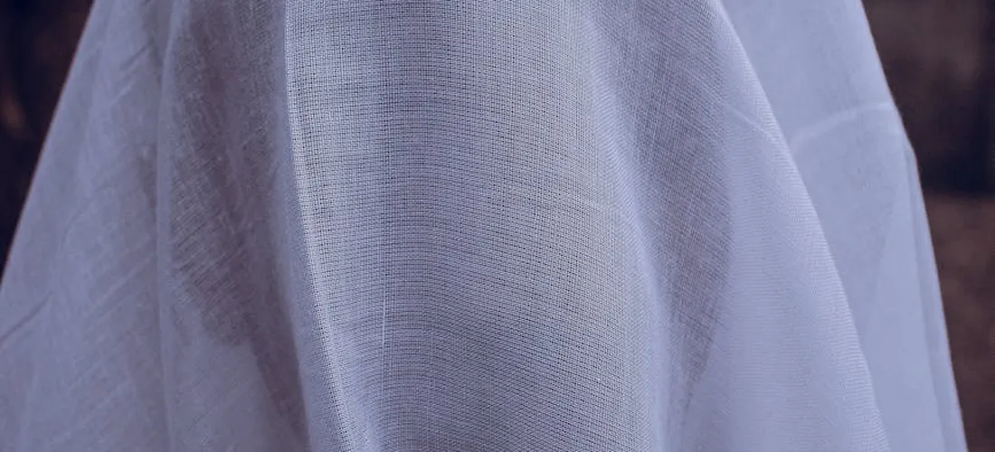Close-up of a white shroud draped over a body, emphasizing modesty and dignity in Islamic funeral preparations