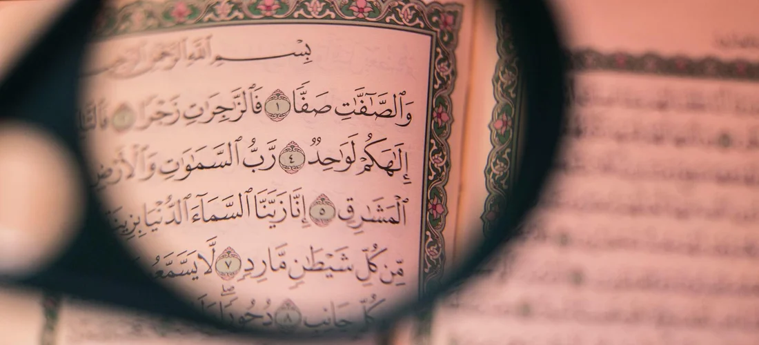 Close-up of Arabic text seen through a magnifying glass