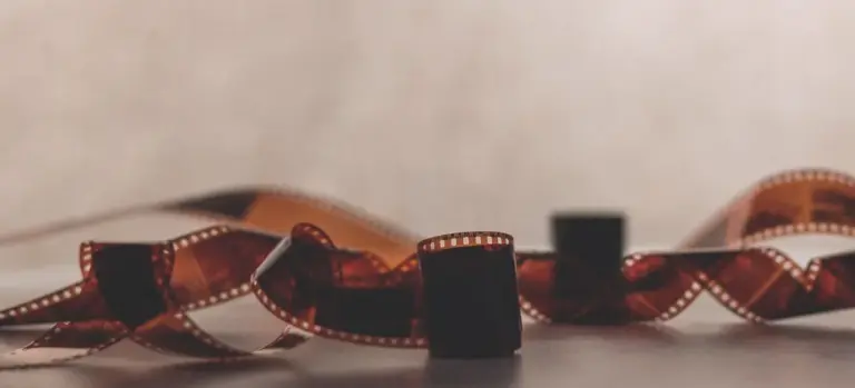 Close-up of curled film strip on a neutral surface, symbolizing memories for a memorial slideshow.