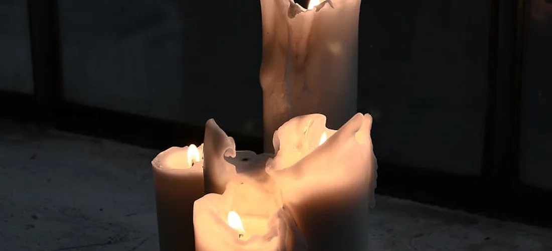 Close-up of lit memorial candles for a somber virtual funeral