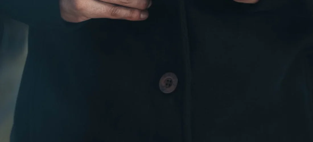 Close-up of a dark formal jacket with a visible button