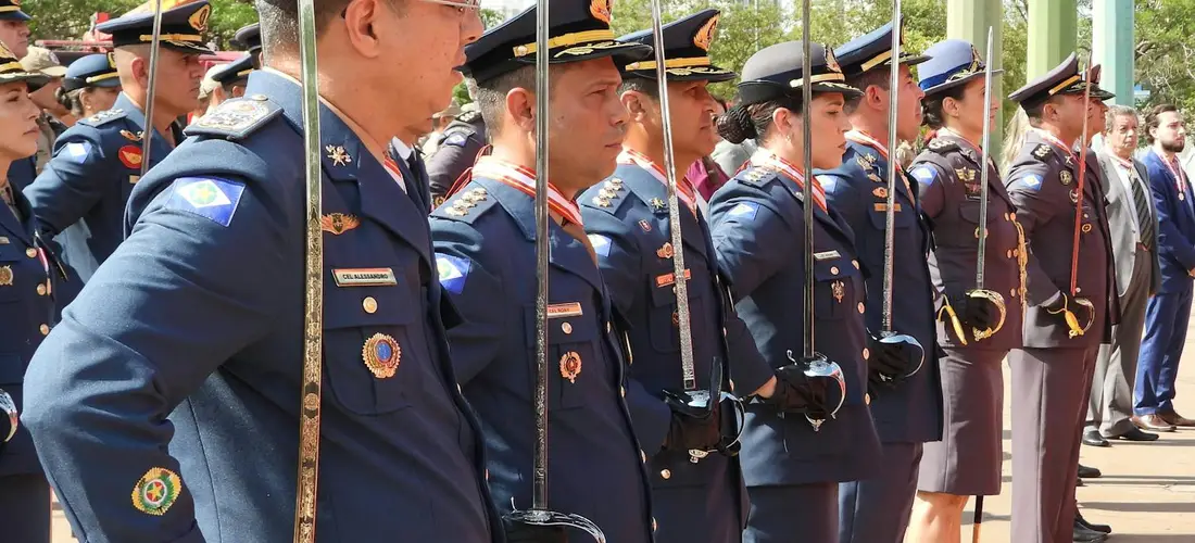 Line of service members in dress uniforms standing at attention with ceremonial swords during a military funeral honors ceremony