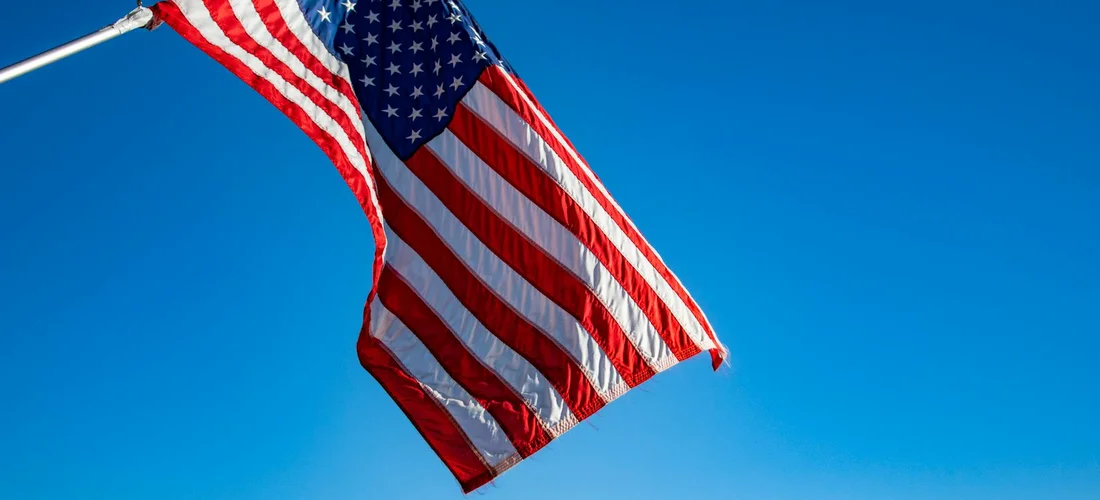 American flag waving against a clear blue sky