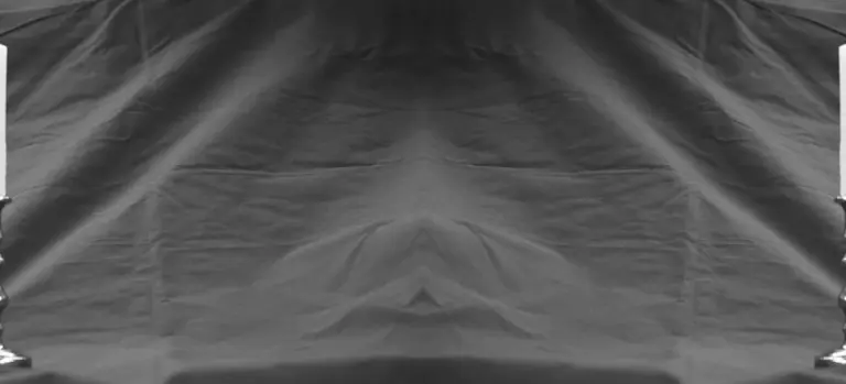 Gray draped fabric backdrop with soft folds, studio setting