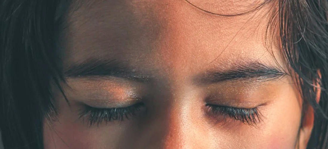 Close-up of a person's closed eyes, conveying quiet reflection.