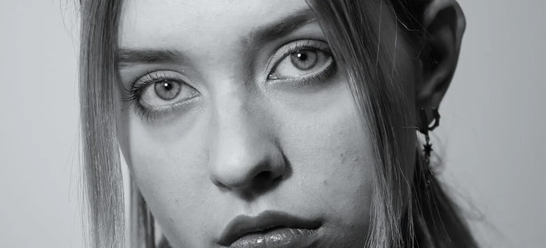Black-and-white close-up portrait of a young woman with a neutral expression.