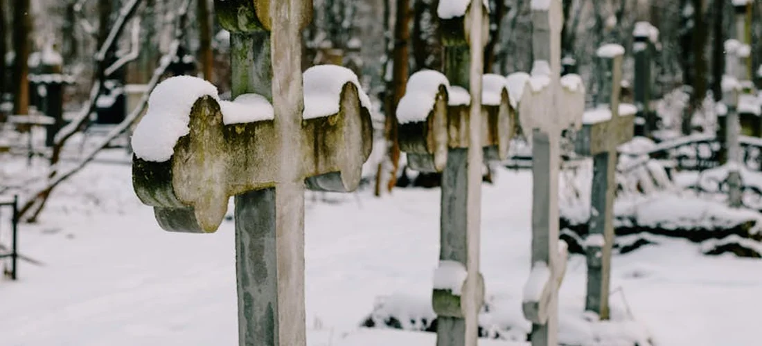 Snow-covered gravestones in a quiet cemetery