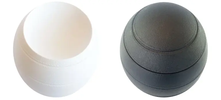 Two spherical cremation urns, one white and one dark gray, displayed side by side